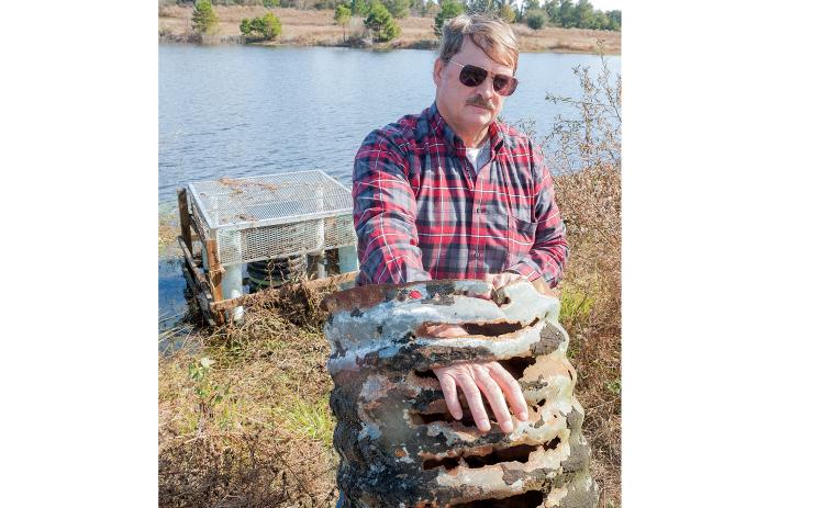 In this 2014 file photo, Jeffrey Hill poses with the rusty pipe at the heart of his dispute. (FILE)