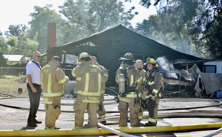 Columbia County Assistant Fire Chief Lance Hill (left) talks with firefighters after they extinguished the flames in a house fire Tuesday morning on SE Montrose Avenue. (TODD WILSON)