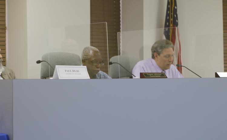 Councilman Eugene Jefferson (left) listens as Todd Sampson speaks during Tuesday’s city council meeting. (JAMIE WACHTER/Lake City Reporter)