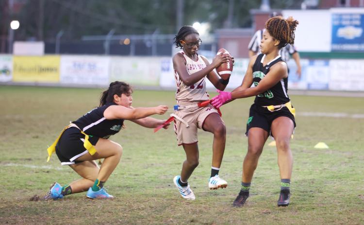 Suwannee’s Amyrah Jones (right) pulls the flag of Florida High’s Rachel White on Wednesday night. (PAUL BUCHANAN/Special to the Reporter)