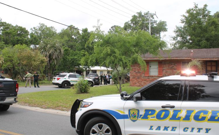 Law enforcement officers surround a residence on the north side of Lake City on Wednesday afternoon. Katrell Hubbard had eluded  custody since March 30 after he fled on foot following a traffic stop. (TONY BRITT/Lake City Reporter)