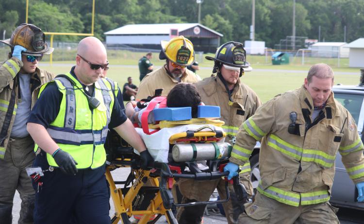 First responders aid a Fort White High School student who was portraying an injured person during a mock crash demonstration Thursday at the school. (TONY BRITT/Lake City Reporter)