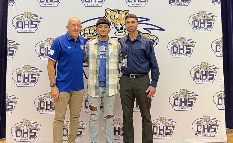 Trinity Baptist coach Dan Robertson (left) stands with Noel Caballero and Caballero’s travel soccer coach Jared Albury during Thursday’s signing ceremony. (COURTESY)
