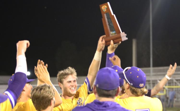 Columbia’s Brent Howard raises the District 3-5A trophy after the Tigers defeated St. Augustine 11-2 on Thursday. (JORDAN KROEGER/Lake City Reporter)