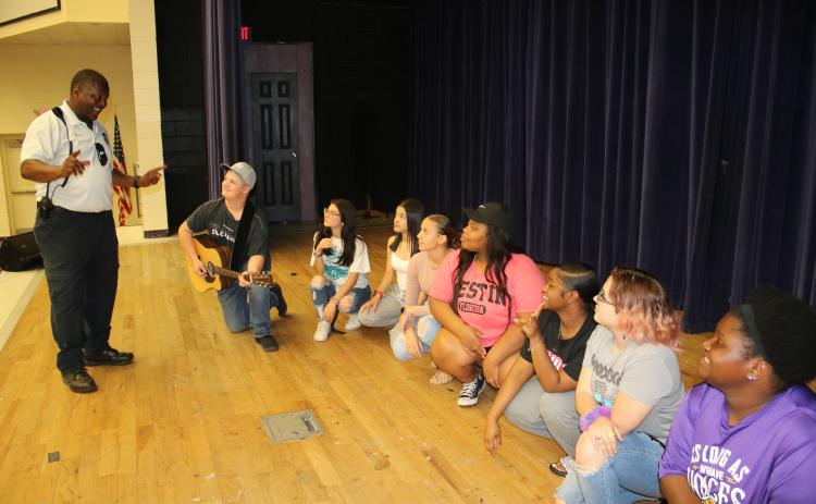 Ronnie Collins (standing), Columbia’s Top Talent founder, talks to final round contestants AJ Busscher (from left), Brynlei Smith, Jailyn Canela, Jalyssa Thomas, Kenzoria Pryor, Kenya Pollock, Keira Fletcher and Cai’Liana Mobley during rehearsal Monday. (TONY BRITT/Lake City Reporter)