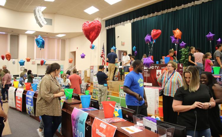 Columbia County School District employees peruse the 500 items in the district auditorium as part of the Employee Appreciation Extravaganza. (TONY BRITT/Lake City Reporter)