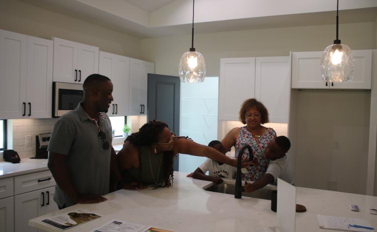 Lennardo Miller (clockwise from left), Pam Miller, Jaxon Miller, Narrie Smith and Brayden Miller, inspect and test kitchen appliances during a Parade of Homes visit on Sunday afternoon. (TONY BRITT/Lake City Reporter)