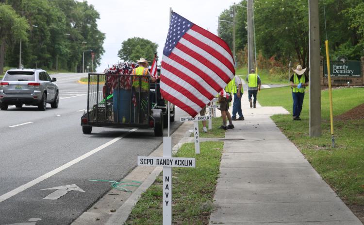 Volunteers with the Republican Party of Columbia County placed crosses and flags with the America’s Heroes program along State Road 47 on Sunday. (TONY BRITT/Lake City Reporter)
