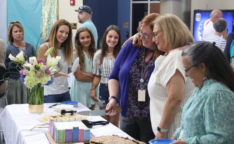 Jo Ann Bailey (second from right) hugs FGC Library Director Christine Boatright alongside Bailey’s daughter Jana Robinson (left) and Bailey’s grandchildren, Hannah and Hailey Robinson. (MORGAN MCMULLEN/Lake City Reporter)