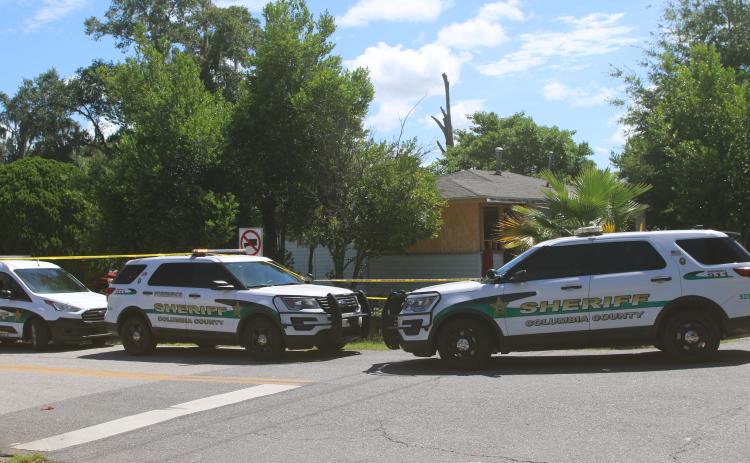 Columbia County Sheriff’s Office vehicles are parked outside a NW Long Street residence where a deputy was injured during a drug bust Wednesday morning. (TONY BRITT/Lake City Reporter)