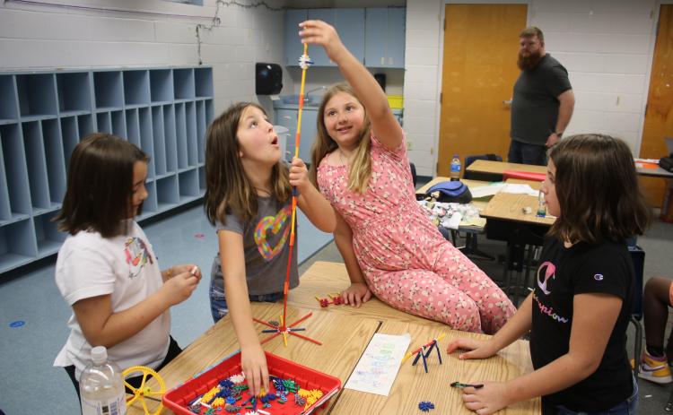 Macy Sirard (from left), Sadie Breeden, Rylee Lupton and Amira Estrada work on building a tower using K’NEX parts on Thursday morning while attending the STEAM summer program at Summers Elementary School. (TONY BRITT/Lake City Reporter)
