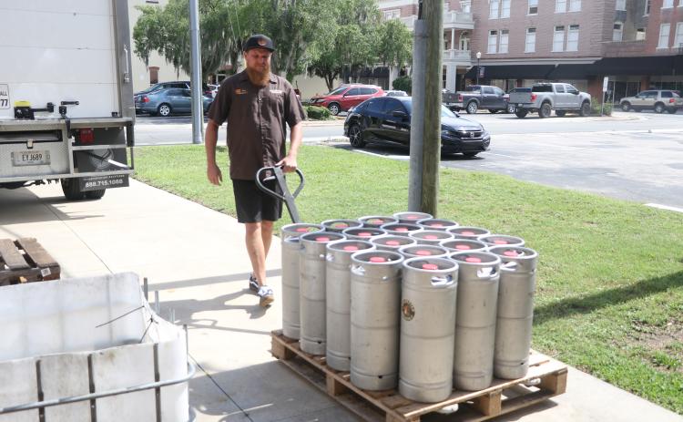 Jonny Frazier walks a pallet of 19 kegs of beer toward a Savannah Distributing truck near the loading ramp at Halpatter Brewing Company on Monday. (MORGAN MCMULLEN/Lake City Reporter)