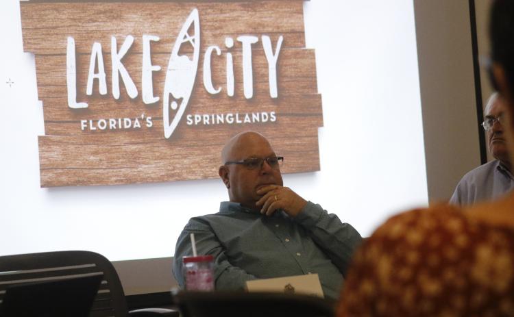 Rocky Ford, the chairman of the Columbia County Tourist Development Council, sits in front of the county’s new tourism logo, which includes the brand of ‘Lake City, Florida’s Springlands.’ (JAMIE WACHTER/Lake City Reporter)