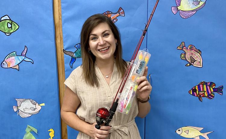 Columbia County Public Library Youth Services Librarian Kate Duong shows off the rod and reel, donated by Fish Florida, that children can receive at the June 24 adventure at Alligator Lake Park. (COURTESY)