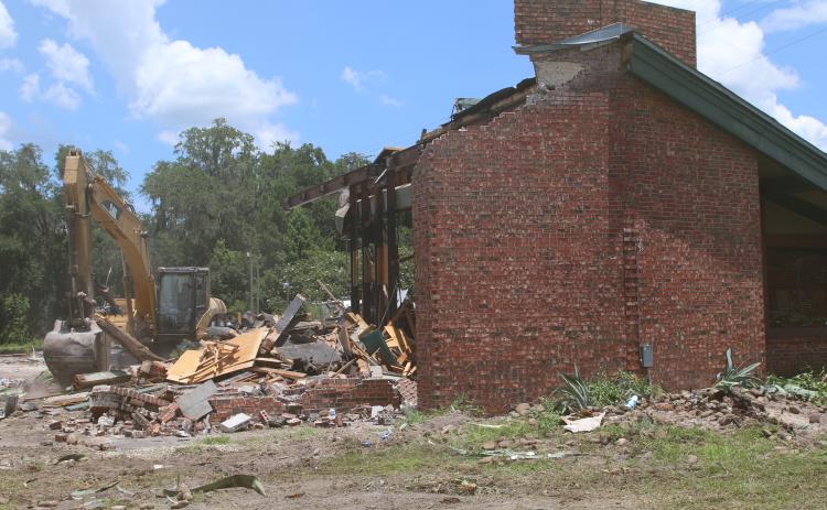 A building that formerly housed a Texas Roadhouse restaurant is torn down Tuesday afternoon. Demolition of the site began last week and is expected to be complete in the next few weeks. (TONY BRITT/Lake City Reporter)