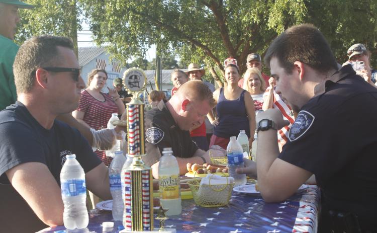 Suwannee County Fire Rescue Captain Chip Leathlean (left) takes a moment during Monday’s inaugural Rudy’s Dawgs Hot Dog Eating Contest. (JAMIE WACHTER/Lake City Reporter)