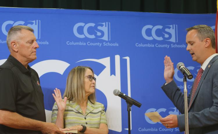 Columbia Clerk of Court Jay Swisher (right) swears in new school board member Cherie Hill ahead of Tuesday’s board meeting. (TONY BRITT/Lake City Reporter)
