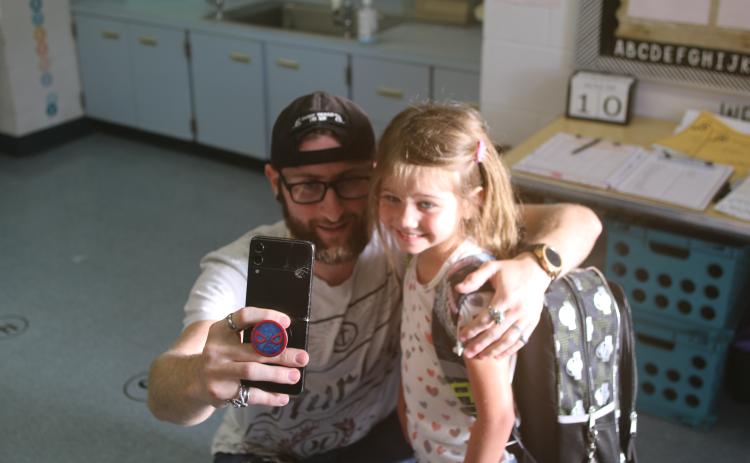 Vincent Tugman takes a selfie with Gwendolyn Tugman as she begins school as a Summers Elementary School kindergartener on Wednesday morning. (TONY BRITT/Lake City Reporter)