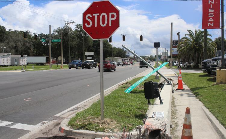 A downed crosswalk pole sits on the sidewalk near the intersection of U.S. Highway 90 and Lake City Avenue Monday afternoon after a single-vehicle crash took it down Sunday morning. (TONY BRITT/Lake City Reporter)