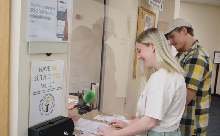 Bailey Lacy, of Lake City, gets help while at the Florida Gateway College financial aid office Monday as Kaiden Flint waits in line. FGC will begin classes for its 16-week fall semester on Monday, Aug. 22. (TONY BRITT/Lake City Reporter)