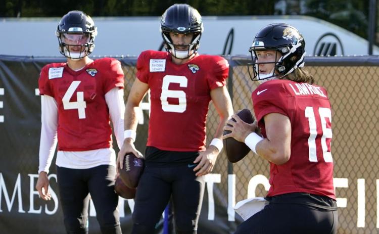 Jacksonville Jaguars quarterback Trevor Lawrence (16) runs through a drill as quarterbacks Kyle Sloter (4) and Jake Luton (6) look on during practice on Sunday in Jacksonville. (JOHN RAOUX/Associated Press)