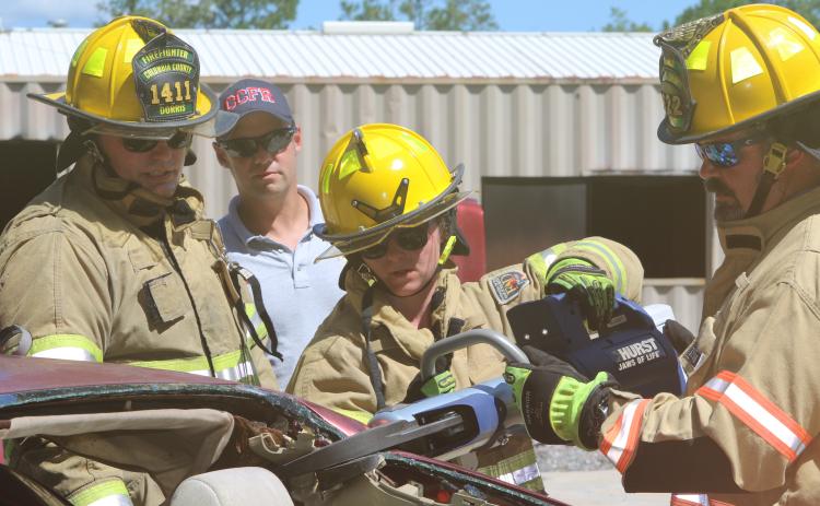 Columbia County firefighters Jessica Islam (center) and Bryan King (right) work with the Hurst Jaws of Life as Tyler Dorris (left) looks on Tuesday. (TONY BRITT/Lake City Reporter)
