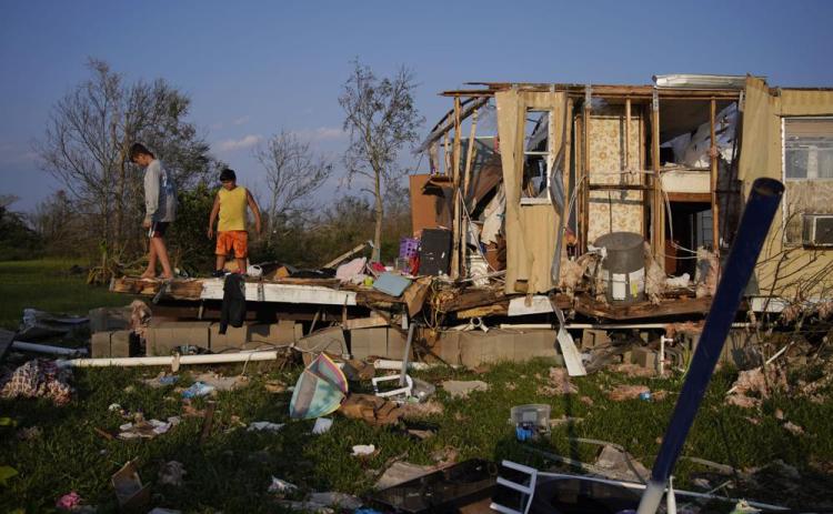 Aiden Locobon, left, and Rogelio Paredes look through the remnants of their family’s home destroyed by Hurricane Ida, Sept. 4, 2021, in Dulac, La. (JOHN LOCHER/AP File)