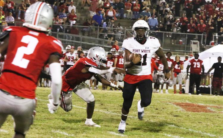 Fort White running back Kamarion Griffin tries to avoid a Williston defender Friday night. (MORGAN MCMULLEN/Lake City Reporter)