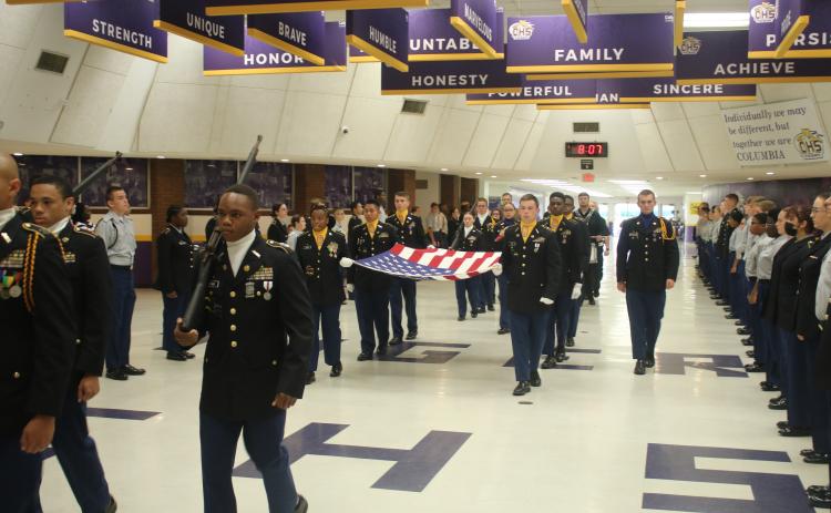 Cadets with the Columbia High School JROTC march the American flag through the school’s commons area Monday morning in a ceremony honoring the victims of the Sept. 11, 2001, terrorist attacks. (TONY BRITT/Lake City Reporter)