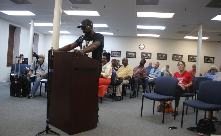 Community activist Sylvester Warren reads off the reason for a ‘penalty flag’ being thrown against Councilman Todd Sampson during the Lake City Council meeting Monday evening. (TONY BRITT/Lake City Reporter)
