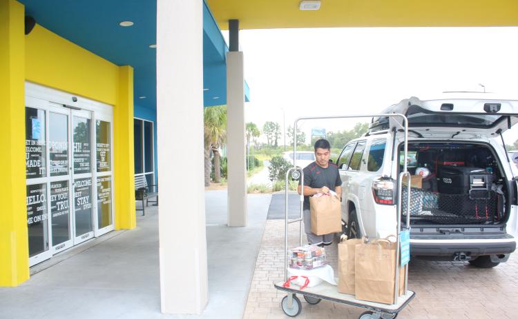 Long Vu, from Tampa, unpacks his vehicle at the Tru by Hilton hotel in Lake City as he evacuated due to threats from storm surge from Hurricane Ian. (TONY BRITT/Lake City Reporter)