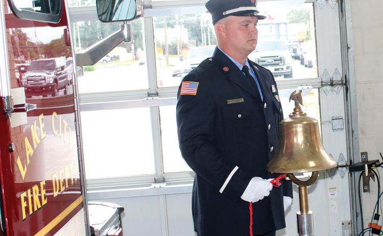 A Lake City firefighter rings a bell commemorating the times that planes struck the Twin Towers and Pentagon on Sept. 11, 2001, during last year’s Patriot Day ceremony. (FILE)