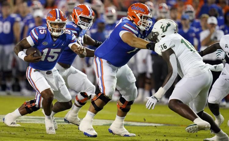 Florida quarterback Anthony Richardson (15) looks for running room as South Florida defensive end Eddie Kelly (16) looks to stop him during Saturday's game in Gainesville. (JOHN RAOUX/Associated Press)