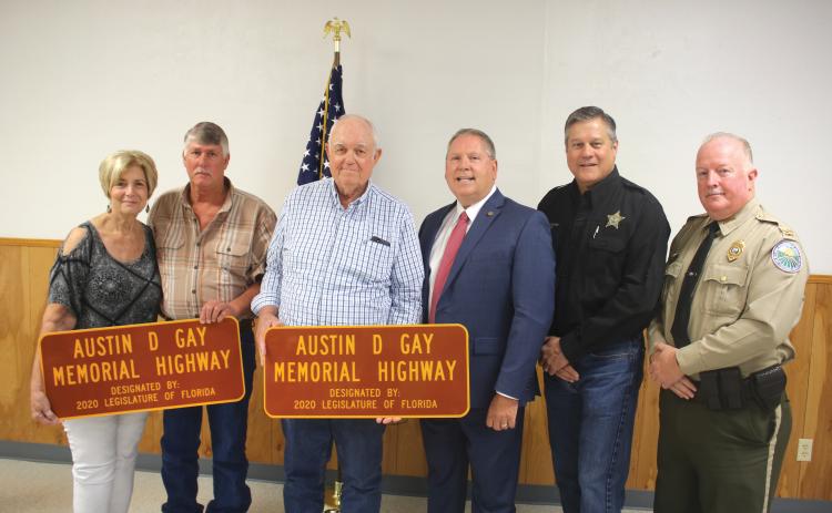 Teresa Register (from left) stands with her brothers Tevis Gay, Dewy Gay, State Rep. Chuck Brannan, Columbia County Sheriff Mark Hunter and Col. James Wiggins, Florida Director of the Office of Agricultural Law Enforcement, following a ceremony where a portion of U.S. Highway 441 was dedicated in honor of slain agricultural officer Austin D. Gay.  The ceremony took place Friday morning at the Deep Creek Community Center. (TONY BRITT/Lake City Reporter)