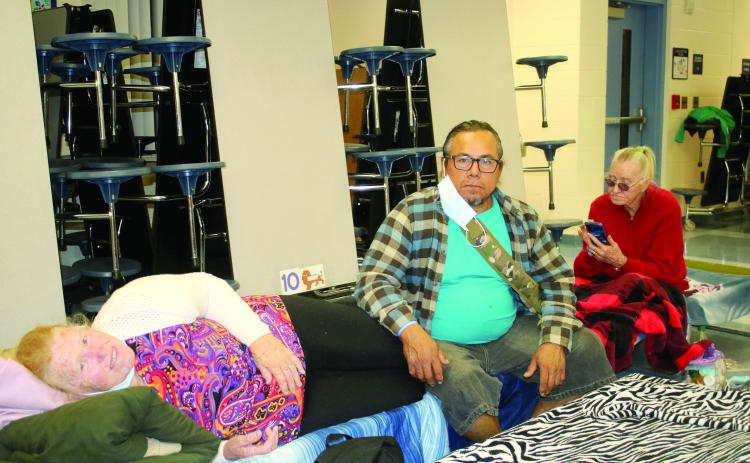 Rachel Orellana (from left), Cesar Aparicio and Mary Zrwalski, sit and unwind in the Pinemount Elementary School cafeteria that served as a Hurricane Ian shelter on Wednesday night. (TONY BRITT/Lake City Reporter)