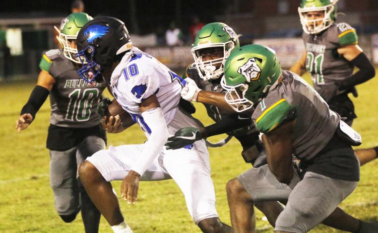 Suwannee cornerbacks PJ Davis (13) and Radarian Griffin (1) tackle Wildwood receiver Jamari Dickens last Friday. (JAMIE WACHTER/Lake City Reporter)