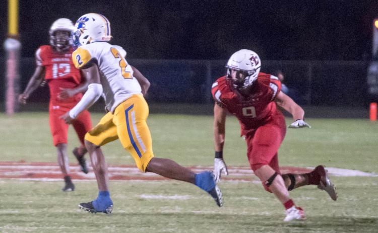 Fort White defensive end Avery Giddens heads in to tackle to Newberry running back Kaleb Woods on Friday night. (CHRISTINA FEAGIN/Special to the Reporter)