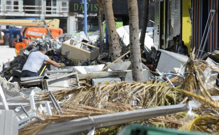 A man hauls debris away from a pizza restaurant that was badly damaged by Hurricane Ian at Fort Myers Beach on Sunday. (JAY REEVES/Associated Press)