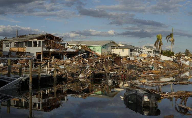 Cars and debris from washed away homes line a canal in Fort Myers Beach on Wednesday, one week after the passage of Hurricane Ian. Hurricane Ian confounded one key computer forecast model, creating challenges for forecasters and Florida residents. (REBECCA BLACKWELL/Associated Press)