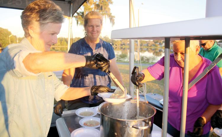 Emmie Chasteen (left) prepares a bowl of corn chowder Thursday evening during the Farm to Table event at Darby Pavilion. (TONY BRITT/Lake City Reporter)