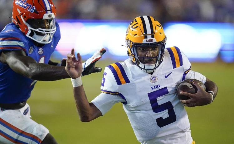 LSU quarterback Jayden Daniels slips by Florida linebacker Brenton Cox Jr. for a 9-yard touchdown run on Oct. 15 in Gainesville. (JOHN RAOUX/Associated Press)