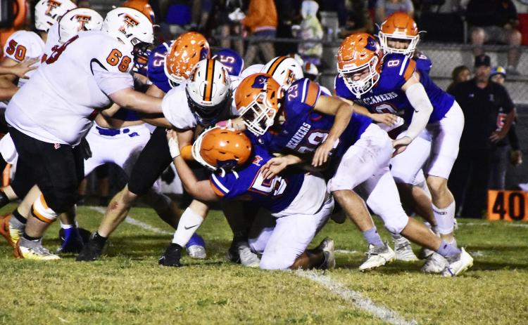 A host of Branford defenders, including Cole Certain (75), Ely Taylor (29) and Trevor Maddox (8) bring down a Trenton ballcarrier Friday. (ROB WOLFE/Special to the Reporter)
