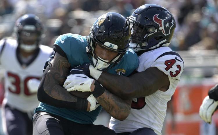 Jacksonville Jaguars tight end Evan Engram is tackled by Houston Texans linebacker Neville Hewitt on Oct. 9 in Jacksonville. (PHELAN M. EBENHACK/Associated Press)