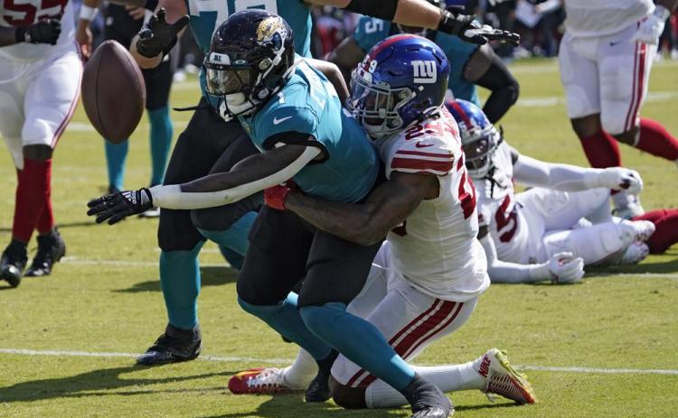 Jacksonville Jaguars running back Travis Etienne fumbles when he gets hit by New York Giants safety Xavier McKinney during Sunday's game in Jacksonville. (JOHN RAOUX/Associated Press)