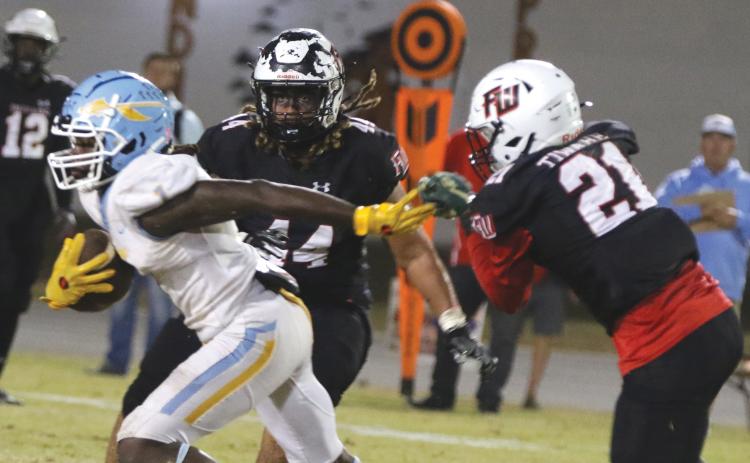 Chiefland running back Dakota Fisher (left) evades a tackle from Fort White’s Kamarion Griffin (44) and Darren Yates (44) on Friday. (MORGAN MCMULLEN/Lake City Reporter)