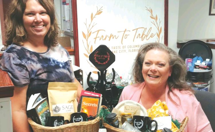 Lake City Community Program Manager Terri Phillips (left), and Kimi Roberts hold vendor baskets promoting the upcoming inaugural Farm To Table, A Taste of Columbia, Lake City, Florida event, which will take place 6:30 p.m. Thursday at Darby Pavilion. (TONY BRITT/Lake City Reporter)