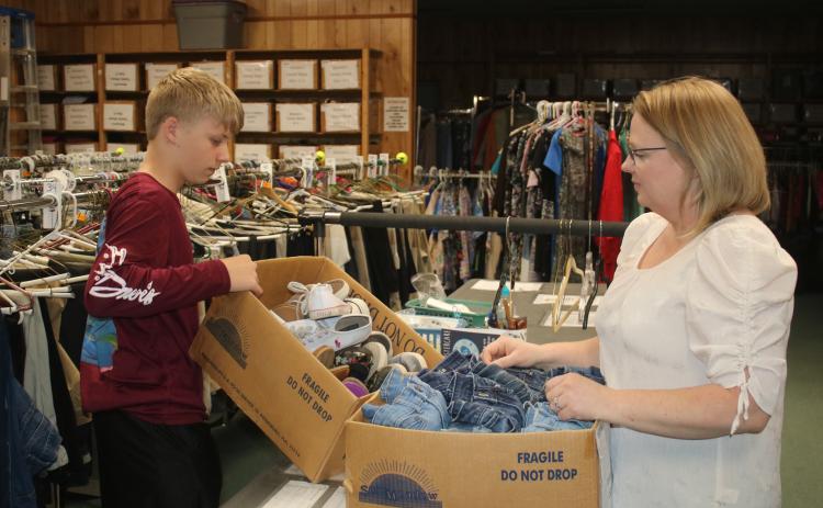 Shannon Hardin (right) sorts through clothing items at the Christian Service Center. Hardin has helped provide clothing for the underprivileged through her Clothes 4 Kids Closet project. (JAMIE WACHTER/Lake City Reporter)