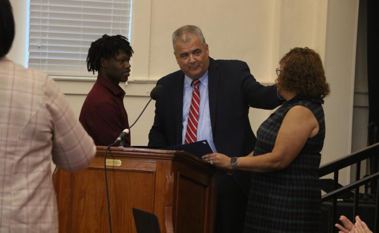 Fort White High School senior Khambrell White (left) is presented a certificate of appreciation by Columbia Schools Superintendent Lex Carswell (middle) and Columbia School Board Chair Narrie Smith on Monday for his actions in helping reunite a dementia patient with her family. (MORGAN MCMULLEN/Lake City Reporter)
