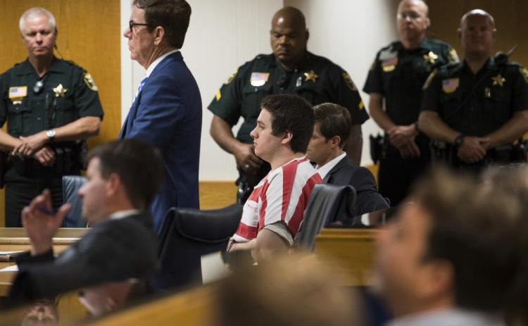 Austin Harrouff, center, wearing stripes, accused of brutally killing a Tequesta couple in 2016, appears Aug. 2, 2019, at the Martin County Courthouse in Stuart. (AP File)