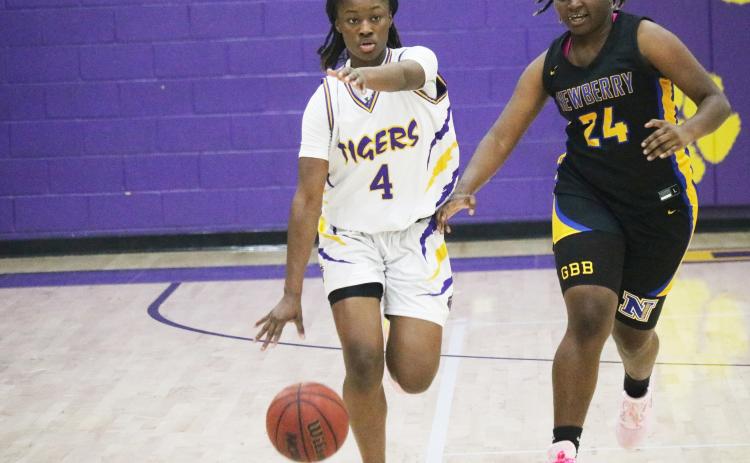 Columbia guard Eriel Baker calls out a play as she dribbles up the court defended by Newberry forward Desia Bryant on Thursday night. (JORDAN KROEGER/Lake City Reporter)